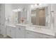 Bright bathroom featuring double sink vanity with white cabinets, quartz countertop, and a tiled walk-in shower at 13714 Jacks Ln, Pineville, NC 28134