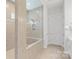 Walk-in tiled shower featuring a glass door, built-in bench, multiple shower heads and tile accent at 13714 Jacks Ln, Pineville, NC 28134