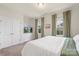 Serene bedroom features soft carpet, a white dresser, a TV and a view to the neighborhood at 13714 Jacks Ln, Pineville, NC 28134