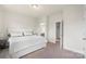 Bright bedroom with soft carpet, neutral paint, and a view of the bathroom and walk-in closet at 13714 Jacks Ln, Pineville, NC 28134