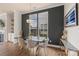 Contemporary dining room with modern chandelier, dark accent wall and large windows overlooking the backyard at 13714 Jacks Ln, Pineville, NC 28134
