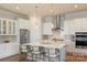 Open kitchen boasts stainless steel appliances, quartz countertops, kitchen island with barstool seating, and pendant lights at 13714 Jacks Ln, Pineville, NC 28134