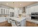 Bright kitchen features a large island with a prep sink, modern stainless appliances, white cabinets and quartz countertops at 13714 Jacks Ln, Pineville, NC 28134