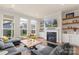 Cozy living room with a fireplace, large windows and hardwood floors at 13714 Jacks Ln, Pineville, NC 28134
