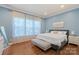 A primary bedroom with blue walls, hard wood floors, and a large bed at 13714 Jacks Ln, Pineville, NC 28134