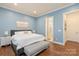 A primary bedroom with blue walls, hard wood floors, and a large bed at 13714 Jacks Ln, Pineville, NC 28134