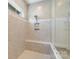 Close up of the beautifully tiled walk-in shower with a glass door, bench, and shower niche at 13714 Jacks Ln, Pineville, NC 28134