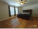 Bright bedroom features wood-look flooring, a ceiling fan, and a large window at 1495 Carson Rd, Cleveland, NC 27013