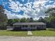 Traditional ranch-style home featuring a welcoming front porch, lush lawn, and a detached storage shed at 1495 Carson Rd, Cleveland, NC 27013