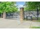 Gated community entrance with stacked stone columns, mature trees and a dark iron fence at 1512 Seigle Ave # 2, Charlotte, NC 28205