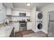 Cozy kitchen featuring stainless steel appliances, granite countertops, and a stackable washer/dryer at 1512 Seigle Ave # 2, Charlotte, NC 28205