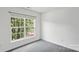 Bedroom featuring a bright window overlooking trees and neutral walls and carpet at 1525 Moss Creek Dr, Harrisburg, NC 28075