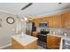 Cozy kitchen with stainless steel appliances, kitchen island, and lovely hanging lights at 1525 Moss Creek Dr, Harrisburg, NC 28075