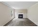 Living room with neutral walls, carpet, and fireplace with black features at 1525 Moss Creek Dr, Harrisburg, NC 28075
