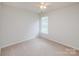 Cozy bedroom features neutral carpet, ceiling fan, and bright natural light from window at 16017 Woodcote Dr, Huntersville, NC 28078
