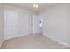 Bright bedroom features neutral carpet, two closets, and door leading to adjacent bathroom at 16017 Woodcote Dr, Huntersville, NC 28078