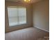Bedroom with beige carpeting and a window allowing natural light to enter the room at 16017 Woodcote Dr, Huntersville, NC 28078