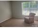 Bedroom with beige carpeting and a chair by a window allowing natural light to enter the room at 16017 Woodcote Dr, Huntersville, NC 28078