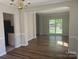 Spacious dining area with elegant chandelier and hardwood floors, adjacent to the kitchen at 16017 Woodcote Dr, Huntersville, NC 28078