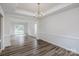 Formal dining room with elegant chandelier lighting, tray ceiling, and hardwood flooring at 16017 Woodcote Dr, Huntersville, NC 28078