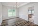 Bright dining room with a view to the backyard, featuring hardwood flooring and elegant chandelier lighting at 16017 Woodcote Dr, Huntersville, NC 28078