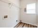 Convenient laundry room featuring wood-look flooring, shelving and large window at 16017 Woodcote Dr, Huntersville, NC 28078