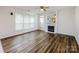 Inviting living room featuring a decorative fireplace, large windows, and hardwood flooring at 16017 Woodcote Dr, Huntersville, NC 28078