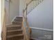 Carpeted staircase with white painted spindles and stained wood railing at 16017 Woodcote Dr, Huntersville, NC 28078