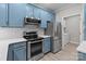 Well-equipped kitchen boasts modern appliances, stylish blue cabinets, and bright subway tile backsplash for easy upkeep at 16610 Amberside E Rd, Cornelius, NC 28031
