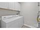 This laundry room has a washer and dryer, overhead cabinets, and lots of light at 16610 Amberside E Rd, Cornelius, NC 28031