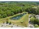 Aerial view of a pond with a fountain, mature trees, lush grass and well-maintained landscaping at 16610 Amberside E Rd, Cornelius, NC 28031
