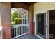 Covered porch features brick and white trim with lush landscaping view at 16610 Amberside E Rd, Cornelius, NC 28031