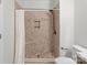 Tiled shower stall with mosaic tile details and a built-in shelf at 16610 Amberside E Rd, Cornelius, NC 28031