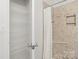 Tiled shower stall with a shower curtain and open shelving unit at 16610 Amberside E Rd, Cornelius, NC 28031