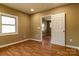Bedroom featuring wood-look floors, tan colored walls, large window, and a doorway at 209 W Marsh St, Salisbury, NC 28144