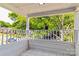 Inviting covered front porch featuring neutral tile flooring and freshly painted white railing with views of mature trees at 209 W Marsh St, Salisbury, NC 28144