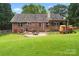 Backyard view of brick home with patio, outdoor kitchen, playhouse, and lush green lawn at 2315 Perry Rd, Denver, NC 28037