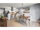 Open-concept dining area with a wooden table, white chairs, and a view into the modern kitchen at 2315 Perry Rd, Denver, NC 28037