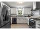 Modern kitchen with stainless steel appliances, bright lighting, and sleek white cabinetry at 2315 Perry Rd, Denver, NC 28037