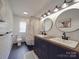 Bright bathroom with double sinks, modern lighting, and decorative shower curtain at 232 W Wilson Ave, Mooresville, NC 28115
