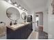 Modern bathroom with dual sinks, wood countertop, stylish mirrors, and modern fixtures at 232 W Wilson Ave, Mooresville, NC 28115