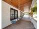 Charming front porch with wooden ceiling and flooring, seating area, and hanging plants at 232 W Wilson Ave, Mooresville, NC 28115