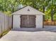 A garage with weathered, wooden doors, white siding, and a concrete driveway at 232 W Wilson Ave, Mooresville, NC 28115