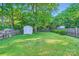 View of a private backyard with a large tree and two sheds at 2424 Pitts Dr, Charlotte, NC 28216