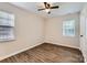 Cozy bedroom with wood-look floors, a ceiling fan, and two windows at 2424 Pitts Dr, Charlotte, NC 28216