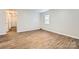 Cozy bedroom with wood-look flooring, neutral walls, and a window offering natural light at 2424 Pitts Dr, Charlotte, NC 28216