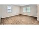 Comfortable bedroom featuring wood-look flooring and two bright windows with blinds at 2424 Pitts Dr, Charlotte, NC 28216