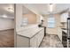 Modern kitchen with white cabinets, light countertops, and a view into the living area at 2424 Pitts Dr, Charlotte, NC 28216