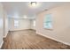 Spacious living room with wood-look flooring, neutral walls, and bright natural lighting at 2424 Pitts Dr, Charlotte, NC 28216