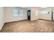 Bright living room with wood-look flooring, neutral walls, and natural light from two windows at 2424 Pitts Dr, Charlotte, NC 28216